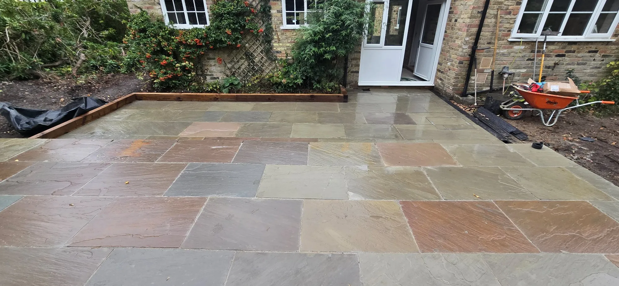 Raj blend sandstone paving running up to the rear of the house, showing its natural colour range