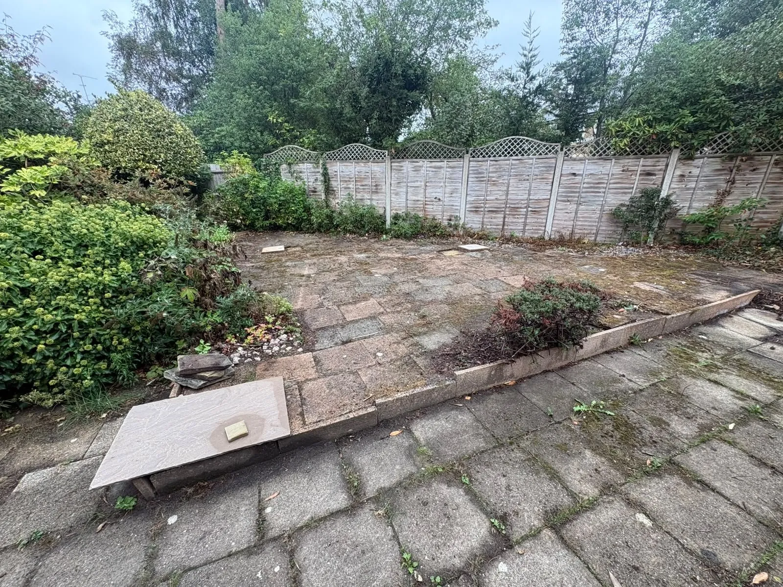 Tired two-level garden with worn paving before Siviter Projects rebuilt it