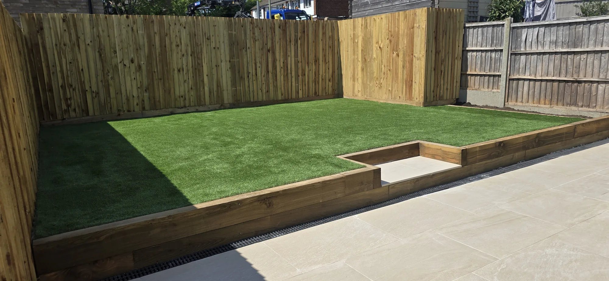 New close-board timber fencing and sleeper-edged artificial lawn in a landscaped Surrey rear garden