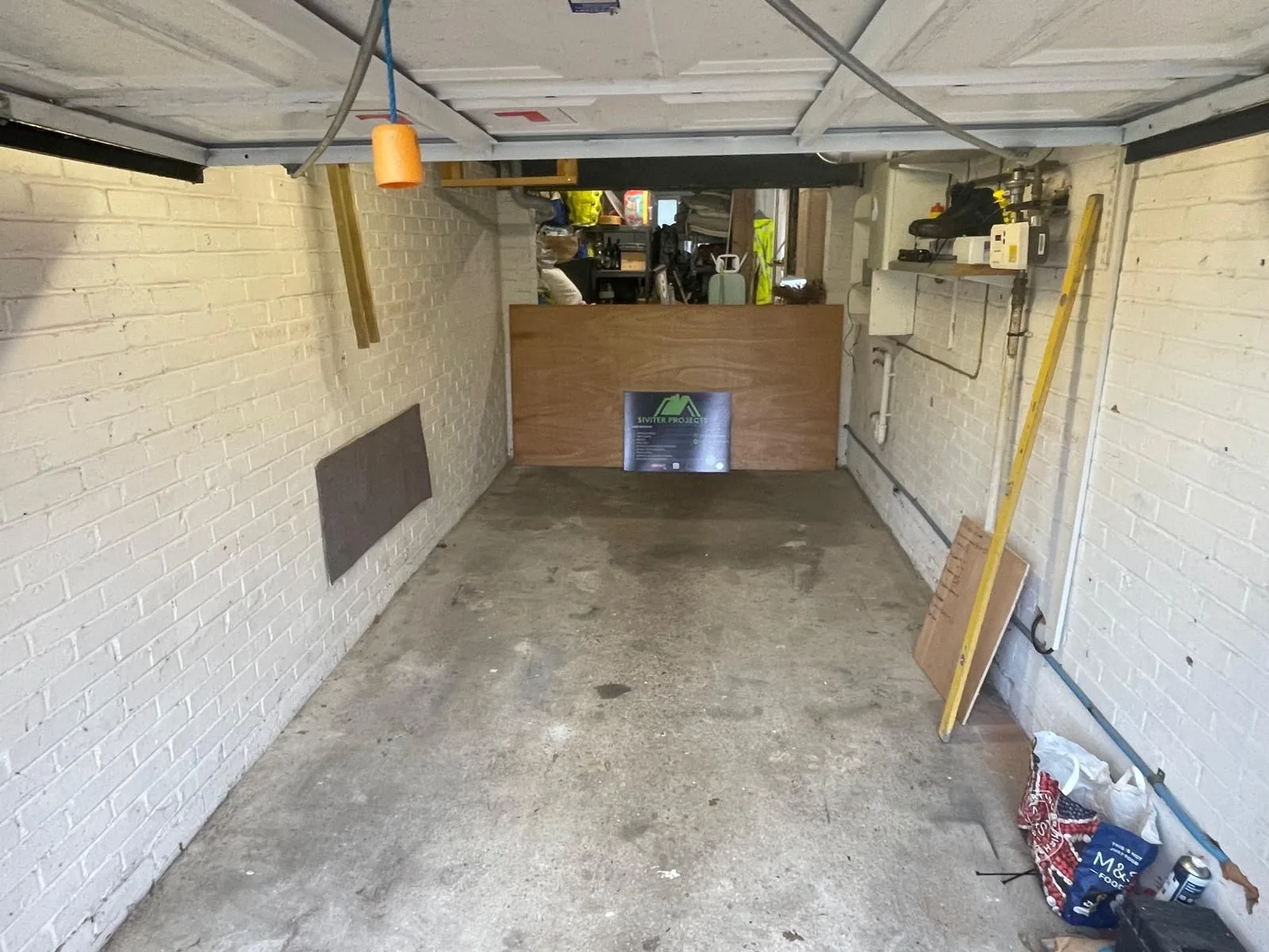 Original garage interior with bare block walls and a concrete floor before conversion