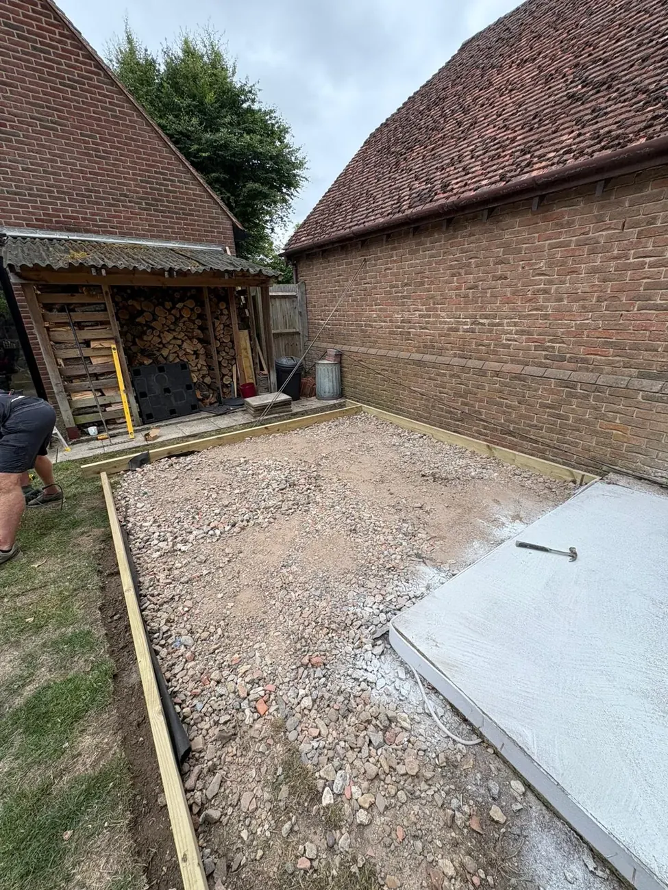 Compacted sub base and timber shuttering prepared for a concrete base on a groundworks site