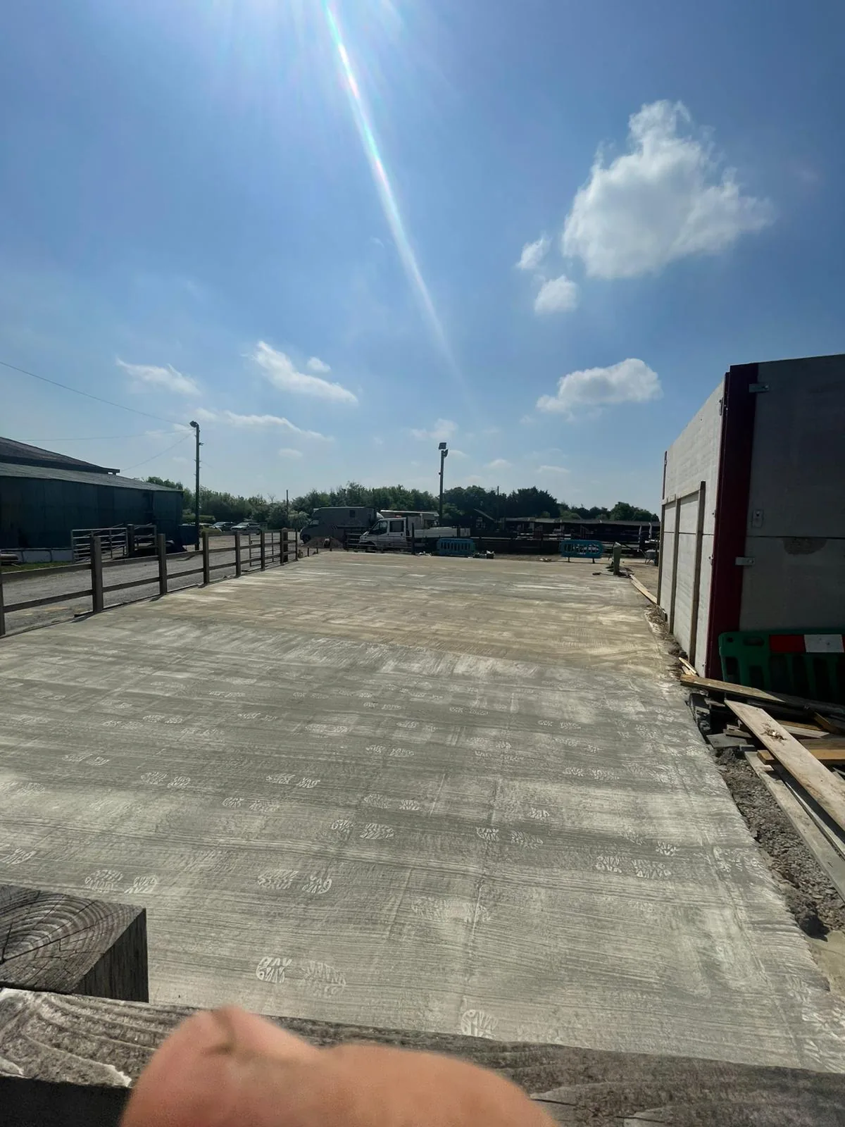 Large newly laid concrete hardstanding slab in a rural yard